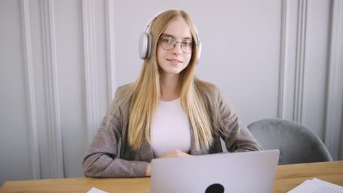 Young Woman with Laptop and Headphones Indoors