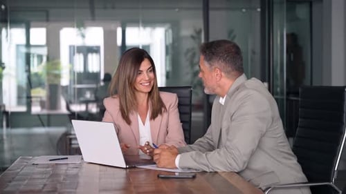 Smiling Business Woman Working on Laptop with Male Colleague at Office Meeting
