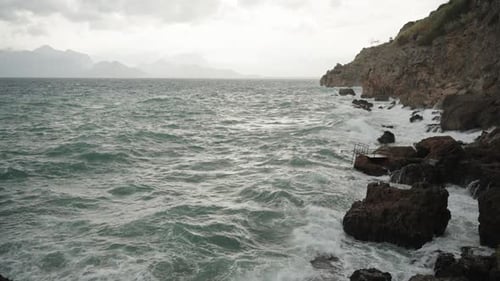 Storm at Sea. Waves Crash Against High Rocks. Slow Motion.
