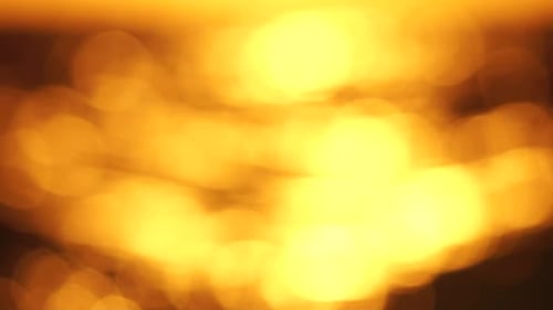 Blurred Golden Sea at Sunset The Sun Reflects and Sparkles on the Waves with Bokeh Illuminating the