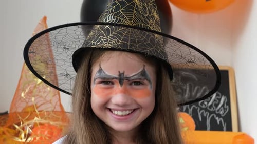 Smiling Child with Witch Hat and Face Paint