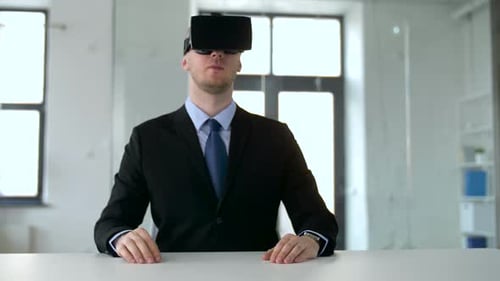 Man in VR Headset Gesturing in Office Setting