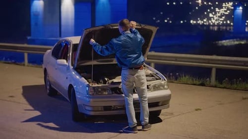 Driver Checks Engine Under Bridge Man Examines Car Engine Beneath Illuminated Bridge Male Driver