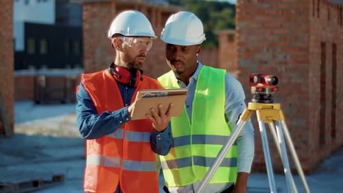 Serious Two Men Engineer Surveyor Discussing Take Measures with Theodolite Use Tablet Compute Stand