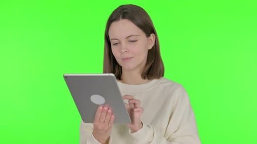 Young Woman Using Digital Tablet on Green Background