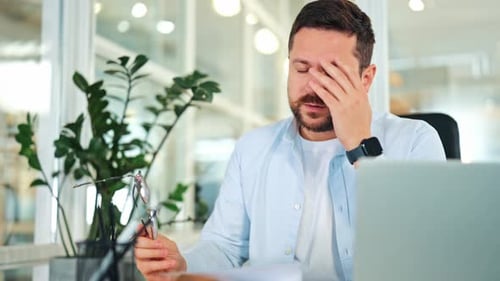 Stressed Businessman Reacts to Bad News Document in Office