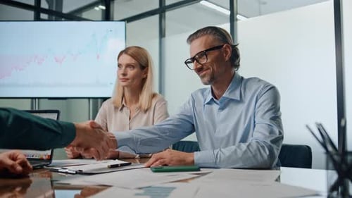Business Meeting Ends with Handshake in Bright Office
