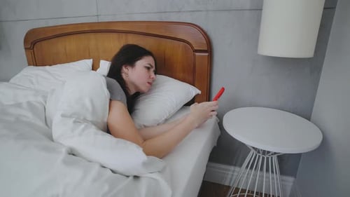 Woman Waking up and Checking Her Phone