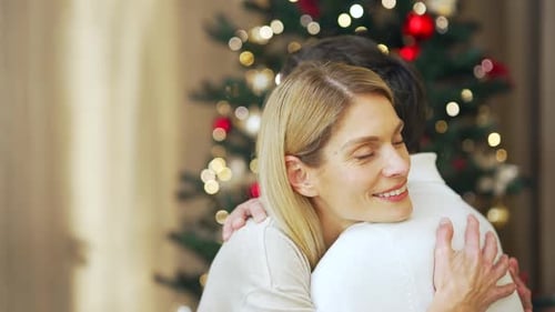 Married couple hugs on Christmas Eve or New Year holidays in cozy house indoors at home Evening.