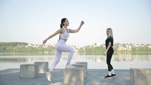 Women Exercising Outdoors Near Lake on Sunny Day
