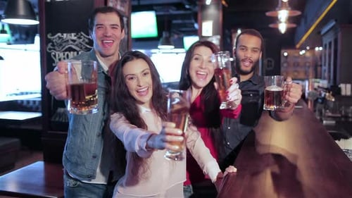 Four Old Friends at the Bar with a Glass of Beer is Welcomed New Friends