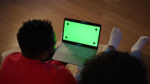 High Angle View Chromakey Laptop in Hands of Young African American Couple Talking Sitting on Floor
