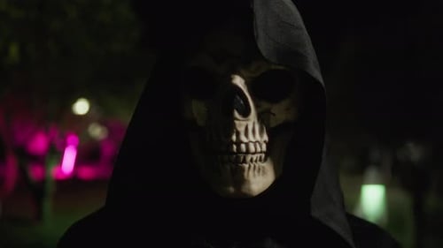 Black Hooded Death At Night In A Forest During Halloween Holiday
