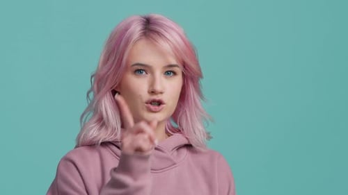 Silence Gesture Junges Hipster-Mädchen mit rosafarbenem Haar, das Zeigefinger zu den Lippen zeigt