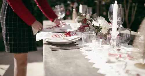 Christmas, hands and person setting table for party, event and celebration gathering at home garden