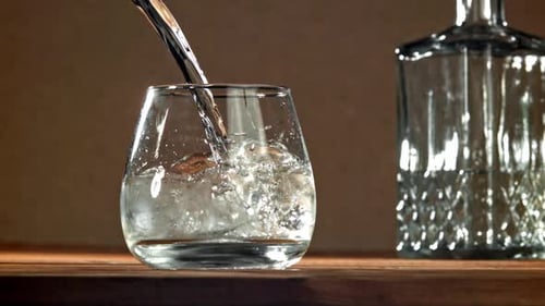 Clear Liquid Pours Into Ice Filled Glass
