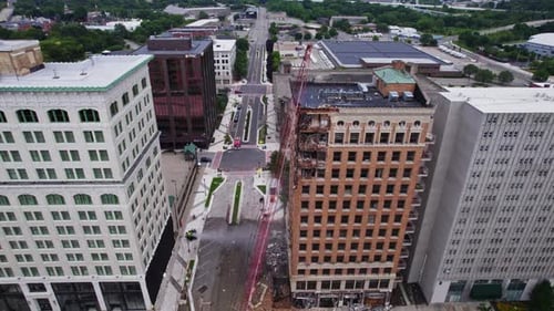 An aerial view of a high-rise building demolition in downtown Youngstown, Ohio. The scene includes a