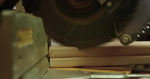 Compound mitre saw cutting pieces of wood - close up - slow motion