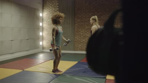 Adult woman exercising in gym with instructor