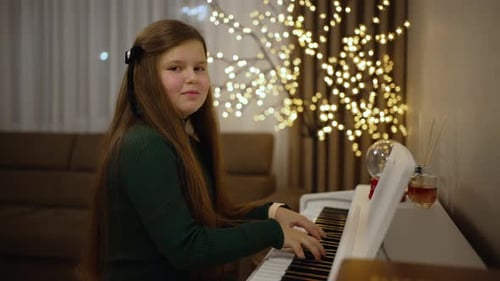 Child Plays Piano in Christmas Decorated Home