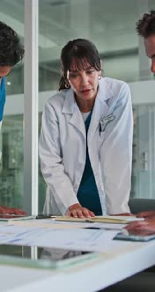 Doctor, team and meeting with records in hospital to review test results, health update or feedback