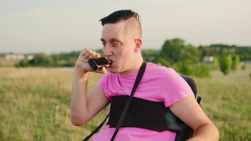 Hombre en silla de ruedas fuma vape durante el fin de semana en Meadow