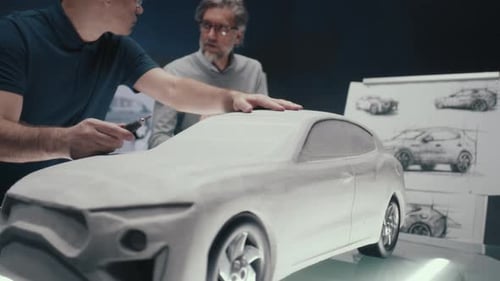 Car Designers Modeling Clay Prototype in Workplace