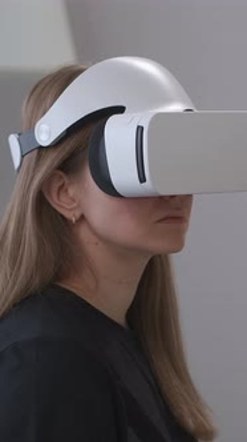 Nahaufnahmen einer jungen Frau mit einem modernen weißen Virtual-Reality-Headset bei der Demonstration