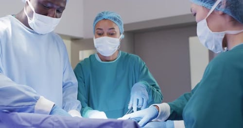 Video of diverse male and female surgeons talking during operation in theatre
