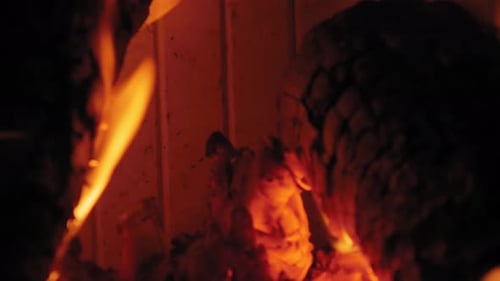 Burning Flame At Fireplace on wooden logs. Close up shot of a yule log burning in a fireplace.