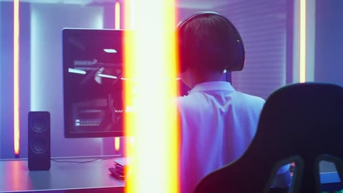 Teen gamer plays video game in colorful room