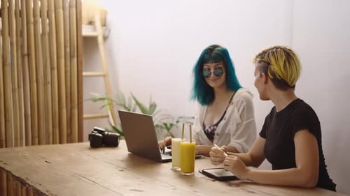 Two Young Adults Working at Table Together