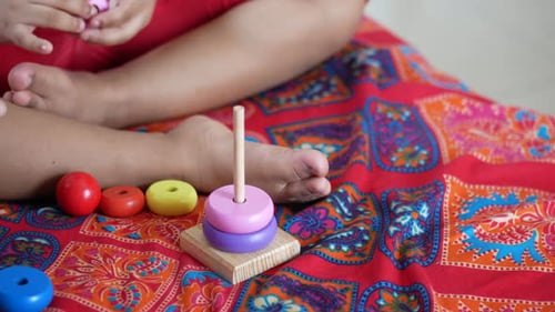 Kind spielt mit einem Babyspielzeug auf dem Bett Konzept zur Entwicklung von Kindern