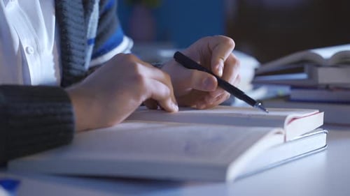 Close-up of male doing research on scientific book.
