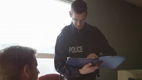 Police officer interviewing perpetrator at precinct HD