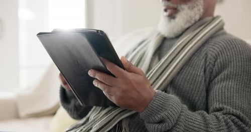 Senior Adult Using Tablet Indoors on Sofa