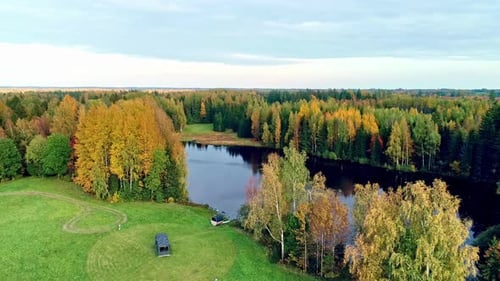 Life in alternative, eco-friendly container houses on the lake shore in autumn nature, circling dron