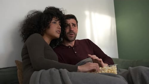 Scared Couple Watching Something on the Couch