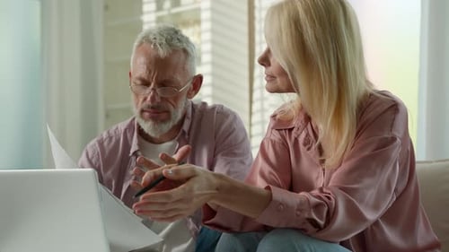 Man and Woman Reviewing Documents at Home
