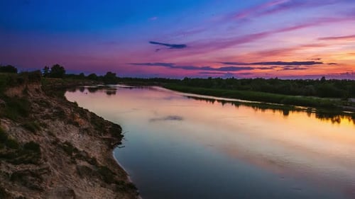 A Stunning Sunset Displaying Over a Tranquil River Featuring Beautiful Reflections and Vibrant