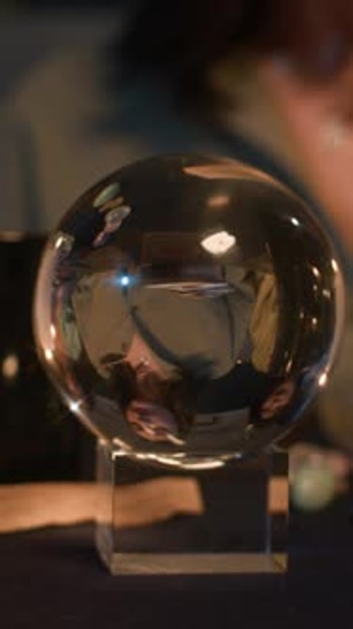 Boule de cristal avec reflet de femmes lors d'une séance de prédiction nocturne