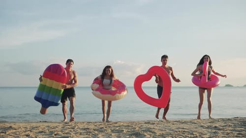 Zeitlupe: Nahaufnahme, Gruppe, Freunde, die rennen, genießen das Leben, Spielen und Freiheit, Strand bei Sonnenuntergang