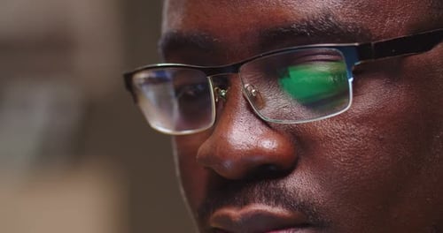 Attractive Afro American Guy Sitting on Couch Working and Typing on Laptop Close Up of Man Face in