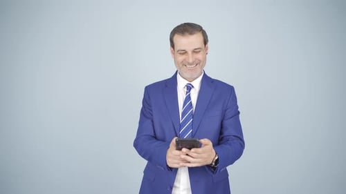 Confident Businessman Using Mobile Phone Wearing Blue Suit