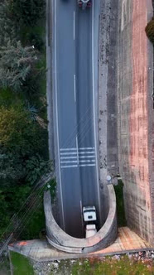 Vídeo vertical de escape costero: vista aérea de la carretera junto al mar hacia el túnel
