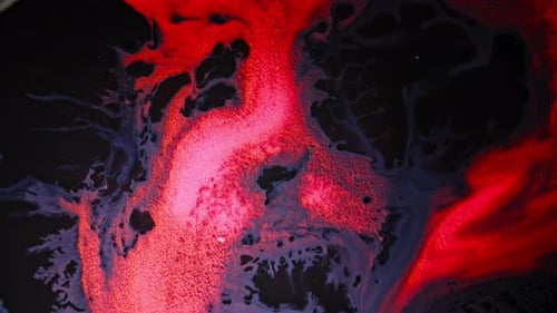 Abstract red and black fluid textures colliding in a dramatic close-up view
