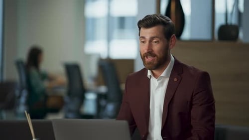 Professional Man on Video Call in Modern Office