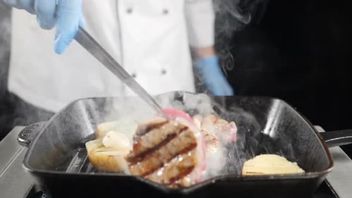 Chef Grilling Meat and Potatoes in Smoky Pan