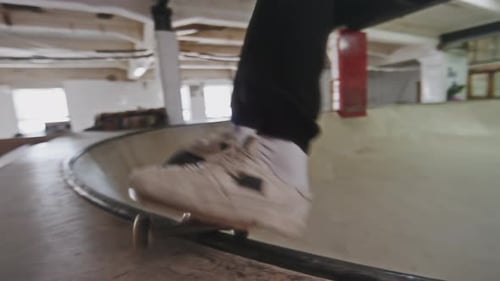 Young Guy Riding Skateboard in Skatepark Bowl
