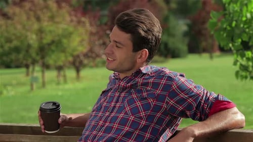 Man with Coffee on a Bench in the Park